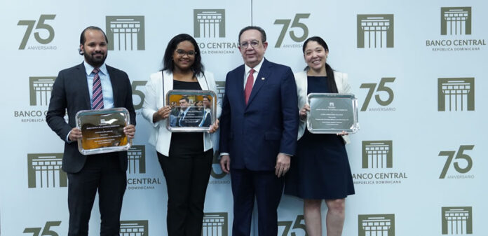 El gobernador Valdez Albizu le entrega el premio a los ganadores del primer lugar: de izquierda a derecha Antonio María Giraldi, Camila Hernández Villamán y Ledys Claribel Feliz Peralta
