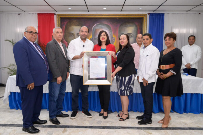 El administrador general del Banco de Reservas, Samuel Pereyra, recibe el reconocimiento como Hijo Distinguido y Meritorio otorgado por la Alcaldía Municipal de Salcedo, de manos de la alcaldesa María Mercedes Ortiz Diloné.